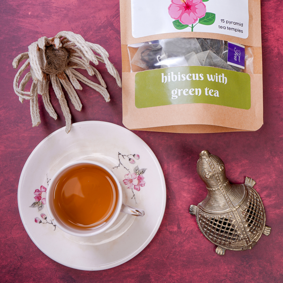 Cup of Hibiscus Green Tea served alongside ArtTeas®  tea pack