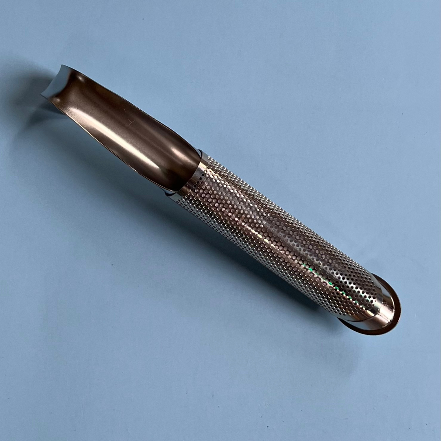 Stainless steel pipe infuser for loose leaf tea on blue background