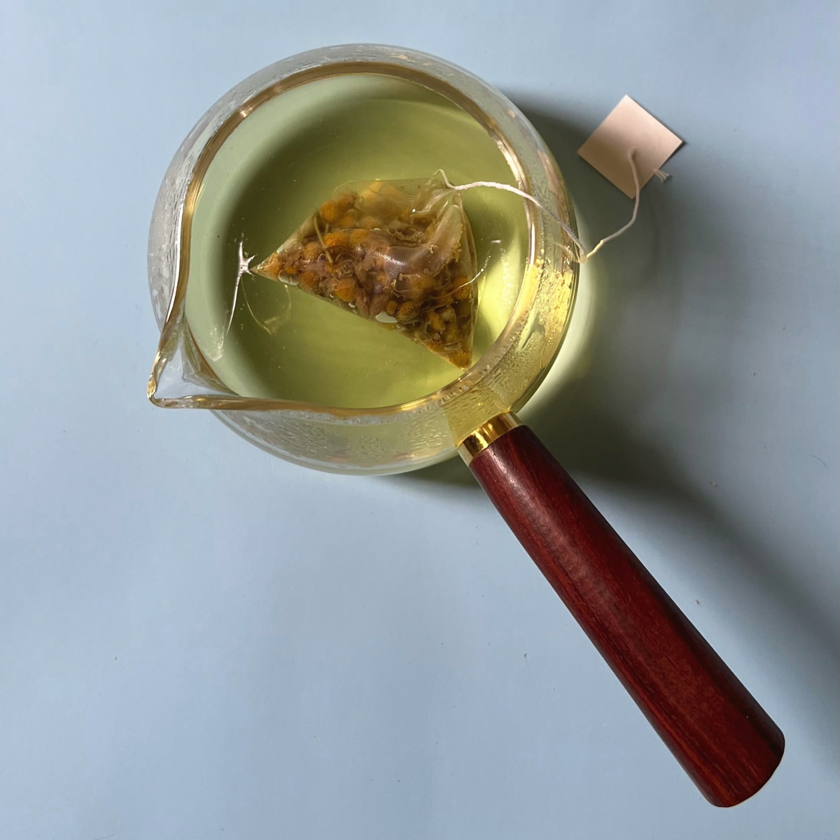 ArtTeas® chamomile flower pyramid tea bag steeping in cup - naturally caming caffeine free herbal tea India.